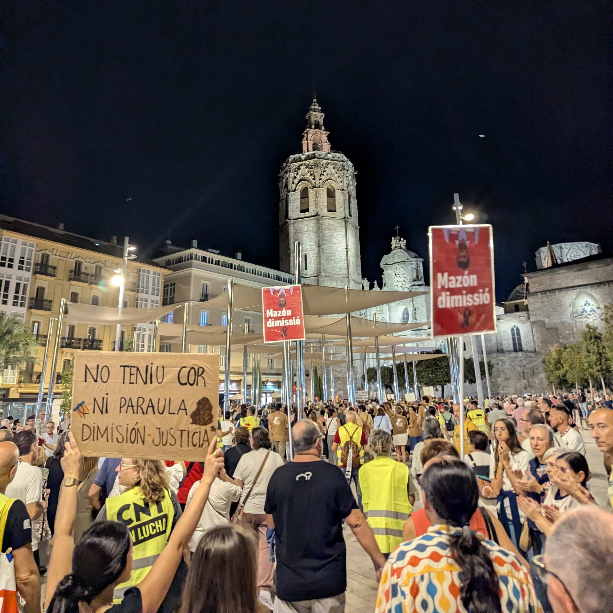 Protest signs showing president Mazón upside down with the text "Mazón dimissió", Valencian for "Resign, Mazón."